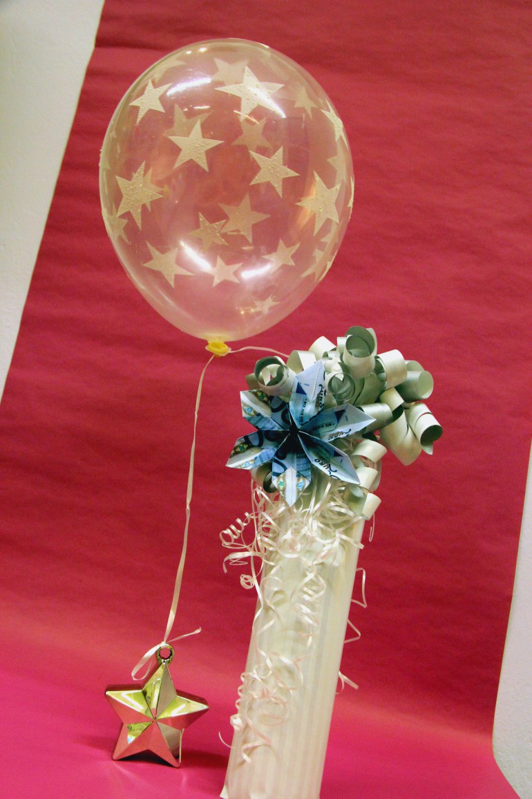 Geschenkverpackung und Geldblume mit Luftballon