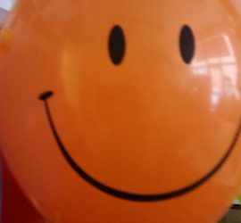 orangefarbener Latexballon Smiley