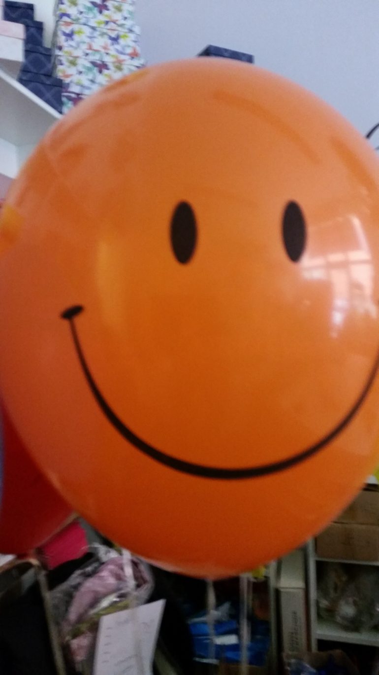 orangefarbener Latexballon Smiley