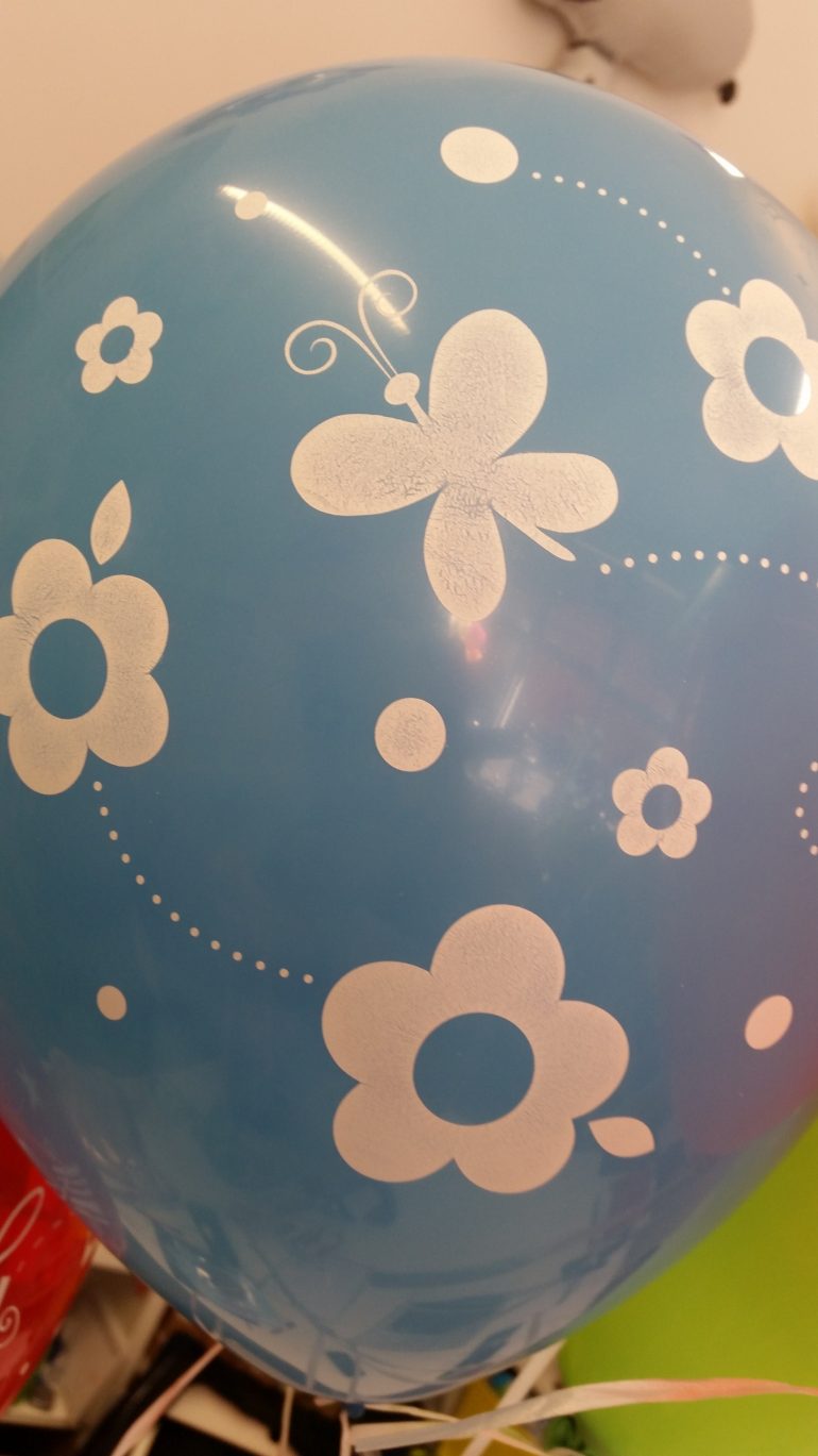 hellblauer Latexballon mit Blumen und Schmetterlingen