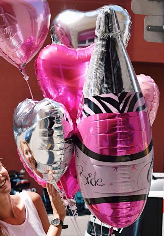 Für den Polterabend: pinkfarbene Champagnerflasche mit Aufschrift Team Bride und pink- und silberfarbene Herzen